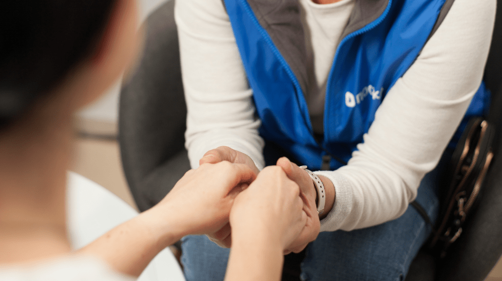 Two women hold hands.