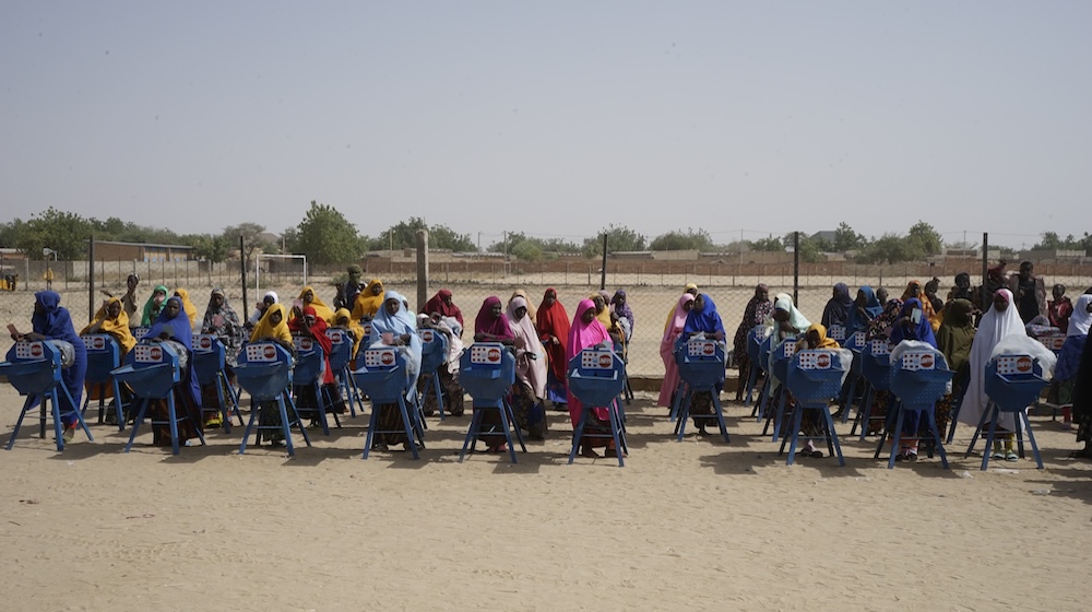 Adolescentes junto a molinillos de semillas con el logotipo del UNFPA