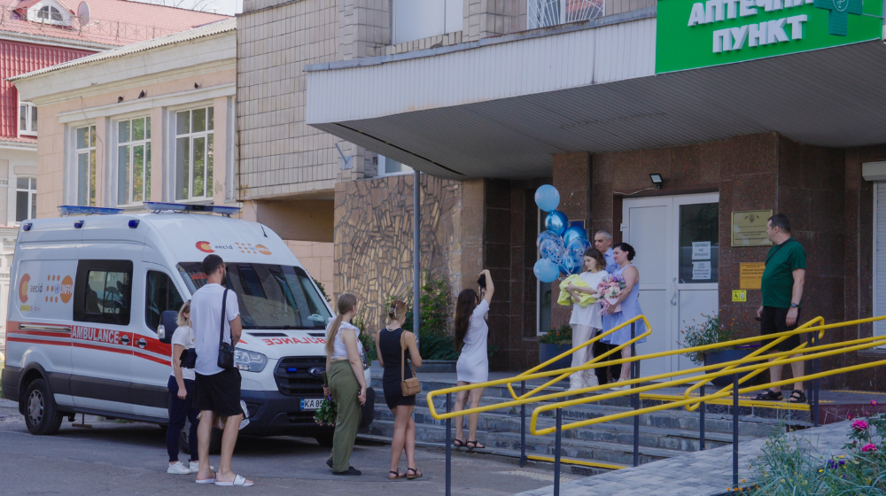  Des gens accueillent une nouvelle mère devant un hôpital