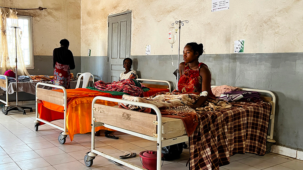 Trois femmes sont assises sur des lits dans une maternité ; une quatrième est debout près de l’un des lits. 