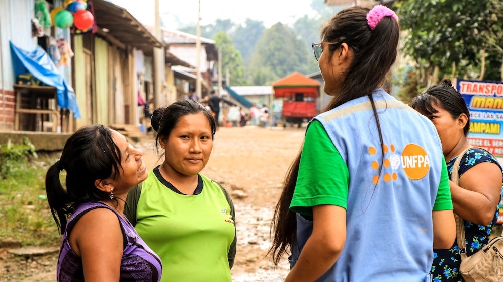 A young woman from Peru is leading a discussion with young women. 