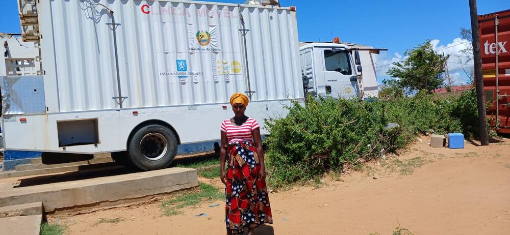 Une femme enceinte debout devant un camion