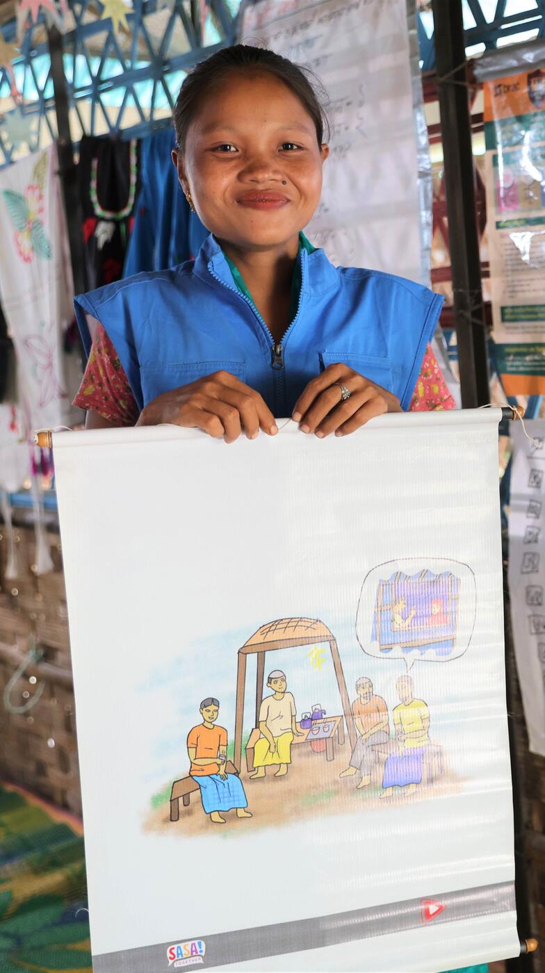 A girl smiles with a poster.