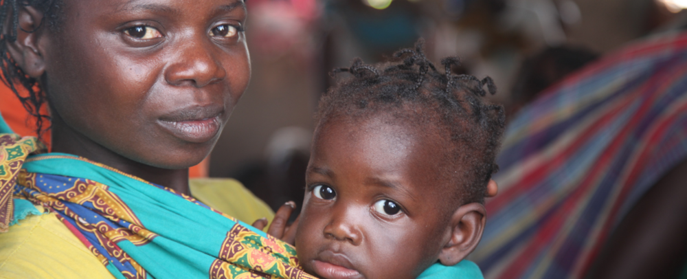 A woman holds a baby. 