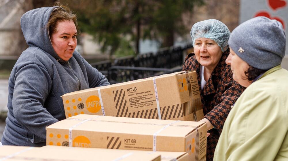 Women carry UNFPA supplies.