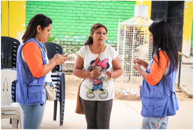 Tres mujeres. Dos son cuidadoras y llevan ropa del UNFPA.