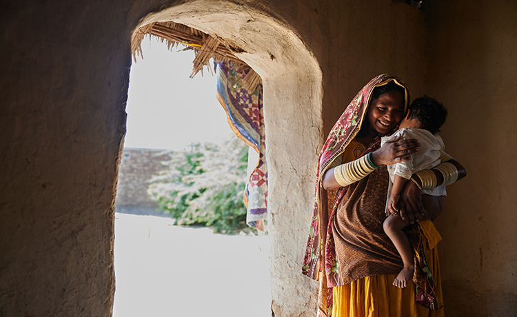 A mother holds her son in her ands against a door