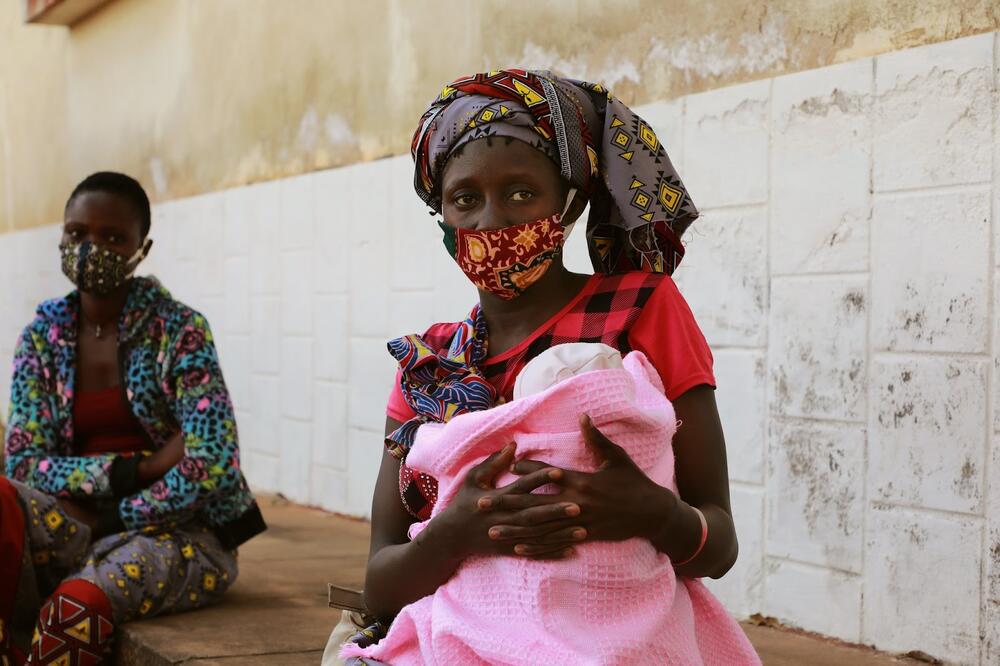 A mother sits with her young child.