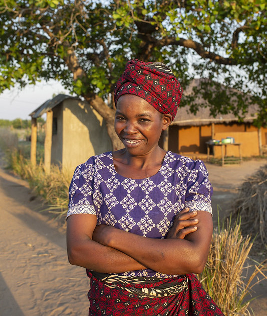 Une femme se tenant devant une maison.