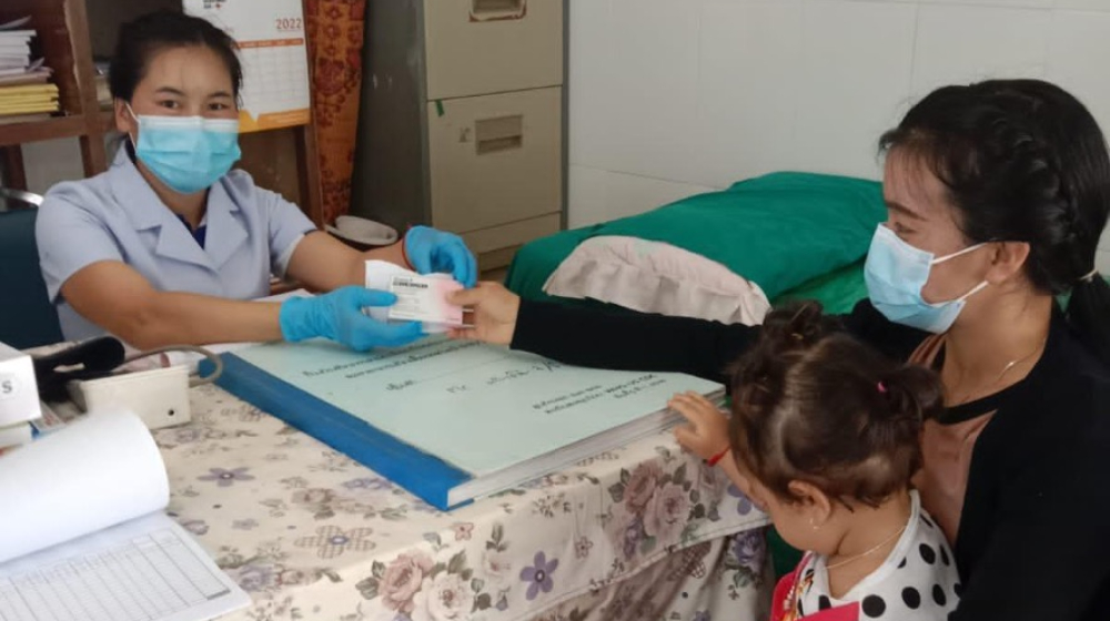 A healthcare worker assists a patient.