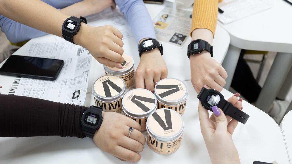 En Moldova, un groupe de personnes pose avec les montres IMMI au poignet.