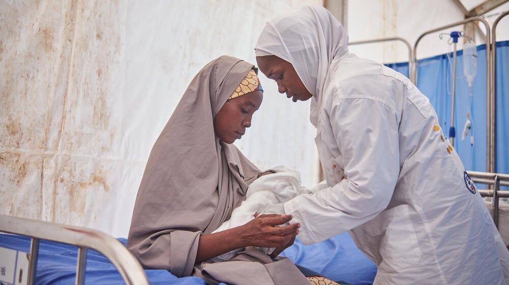 A healthcare worker from Nigeria attends to a mother who just delivered. 