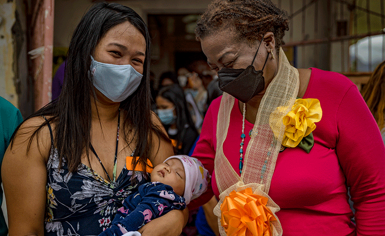 Woman holding baby beside UNFPA Executive Director 