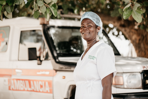 A nurse stands next to ambulance.