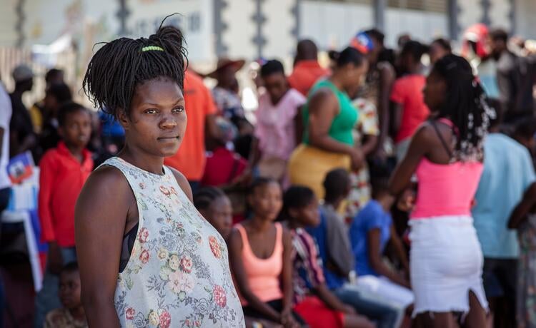 Une femme enceinte, debout devant une foule de personnes