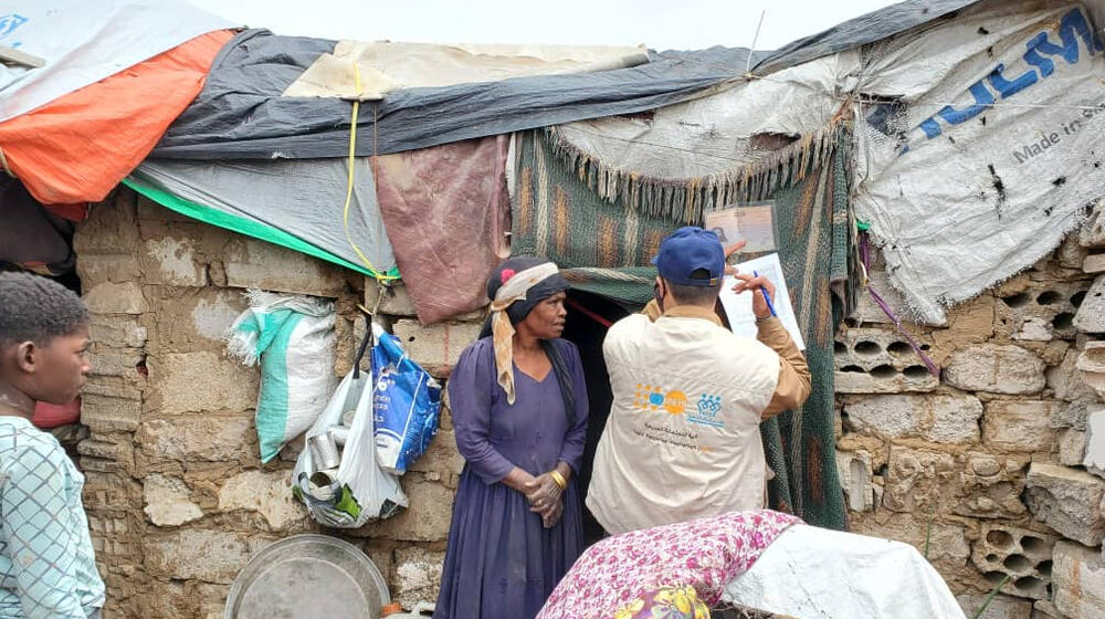 Une femme discute avec des travailleurs humanitaires.