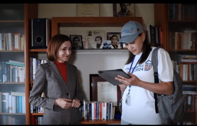 Una mujer sostiene una tableta y entrevista a otra mujer.