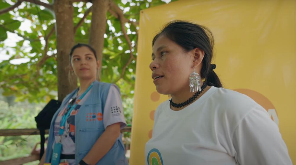 Two women, a UNFPA worker and an indigenous leader, present to an audience.