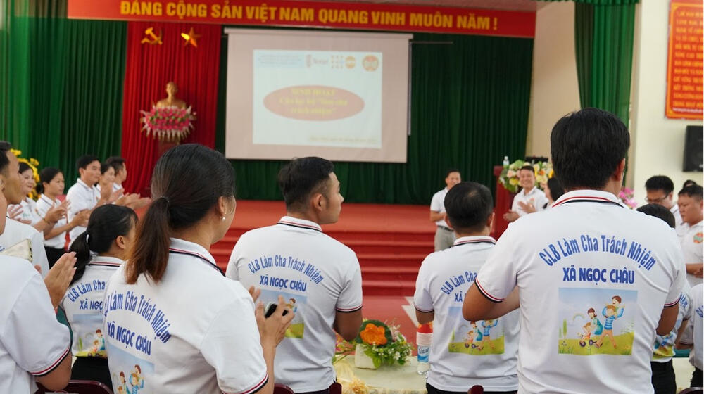 A group of people clap together.