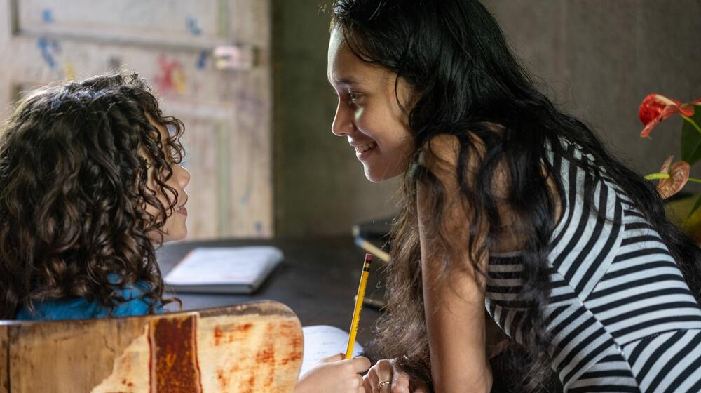 A woman smiles at her child.