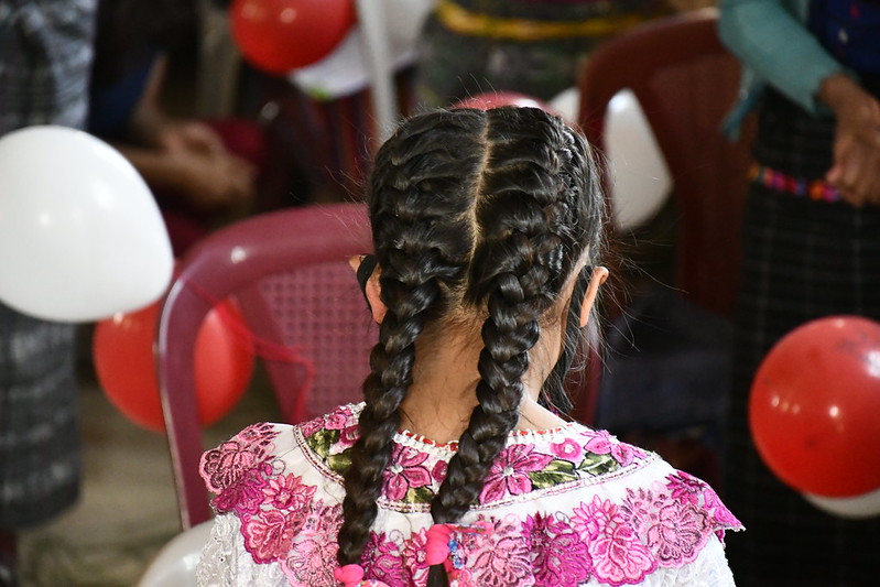 Girl with braids and balloons seen from behind 