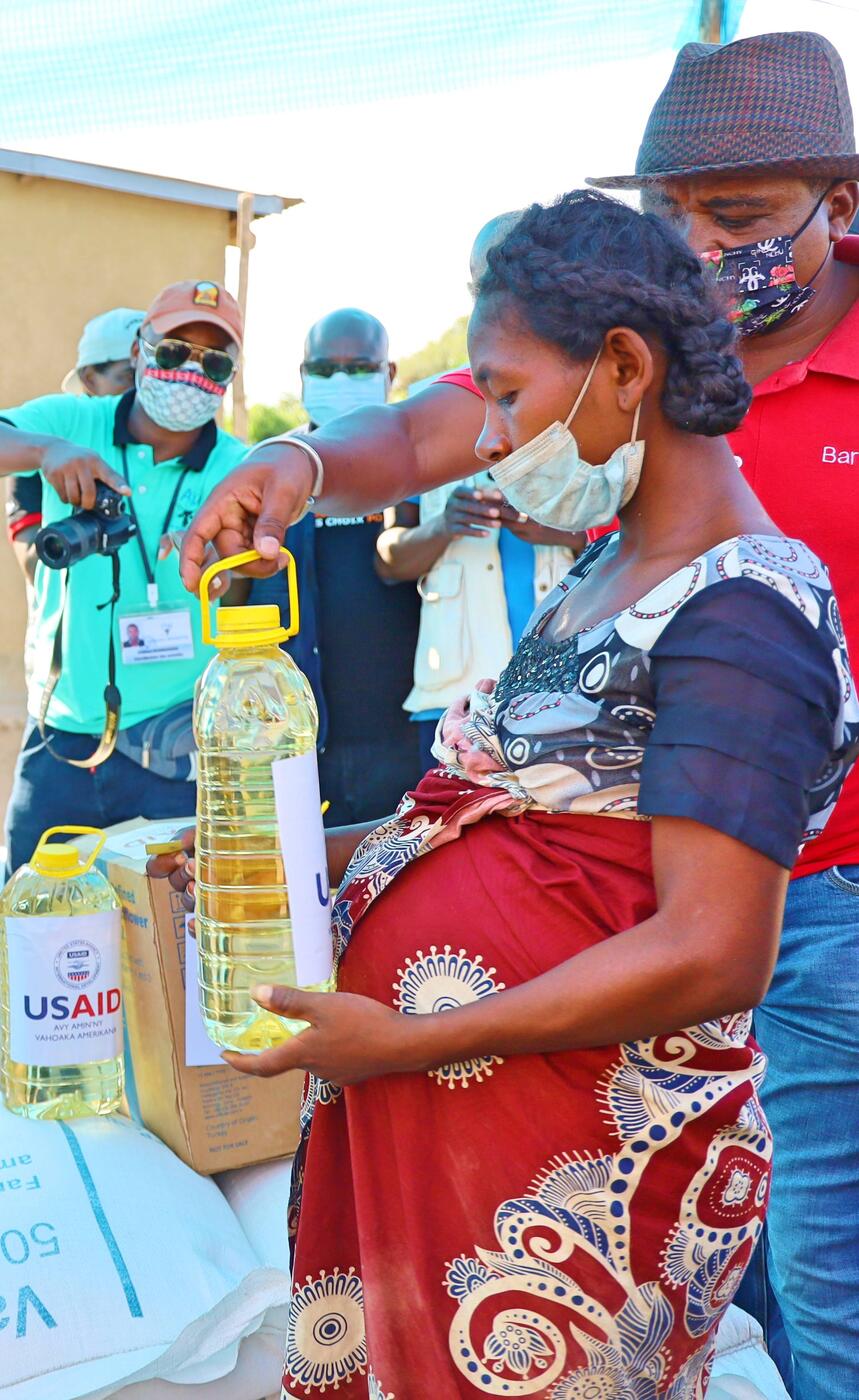 Una mujer recibe raciones de aceite y alimentos.