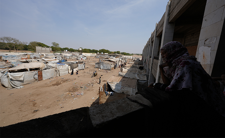 Woman overlooks a camp.