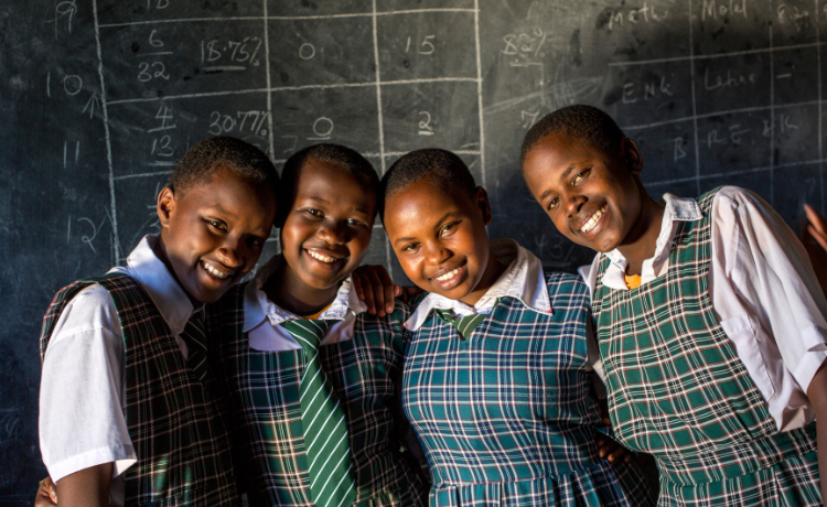 Group of young female students smile through the camera.