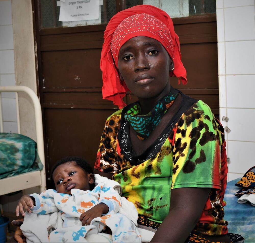 A woman holds a baby. 