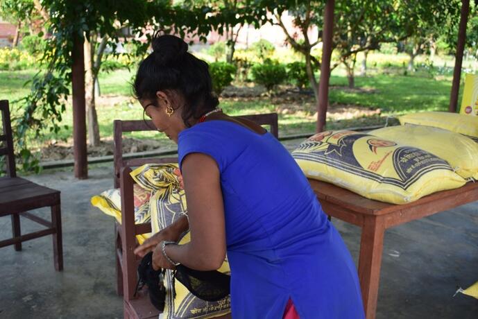 A woman looks at food being distributed. 