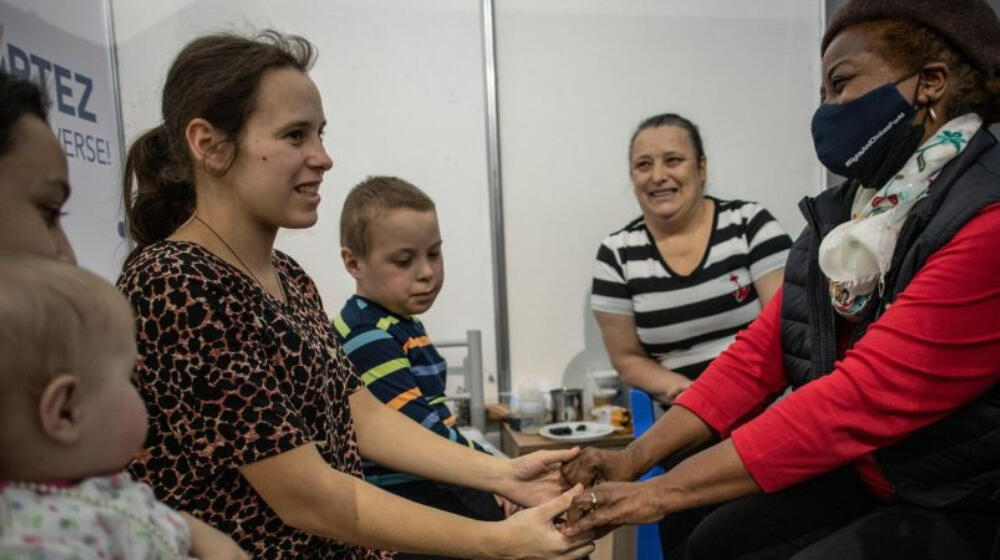 The UNFPA Executive Director holds hands with a woman.