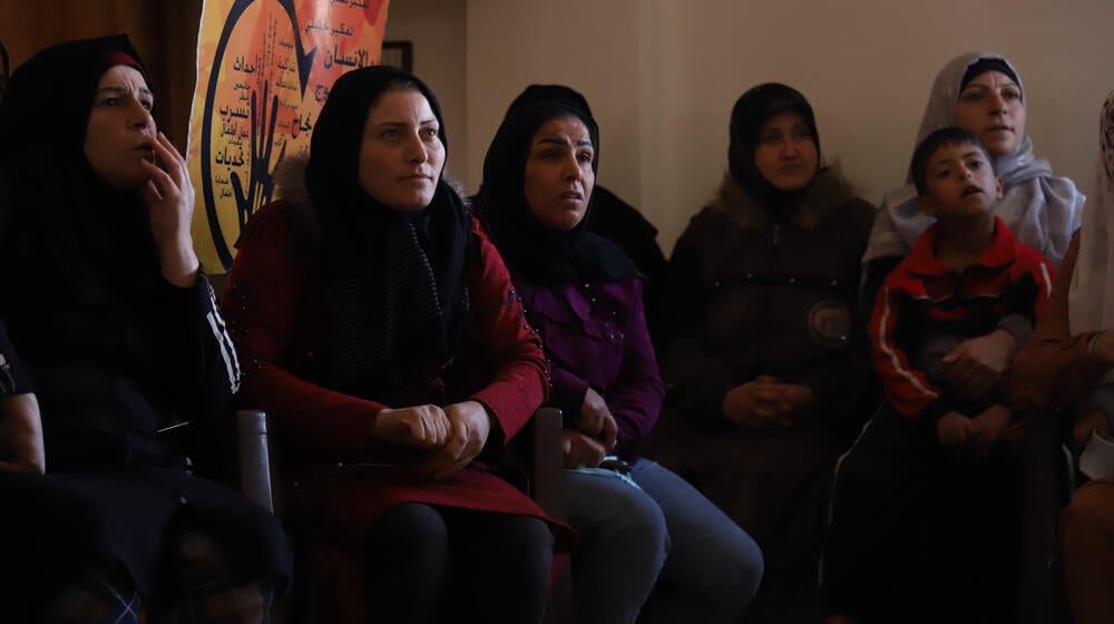 A group of women and a young boy sit inside the Al-Husseiniyah Center in Ashrafieha Village in Rural Homs.