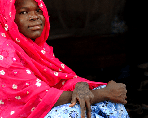 A young woman in bright pink headscarf.