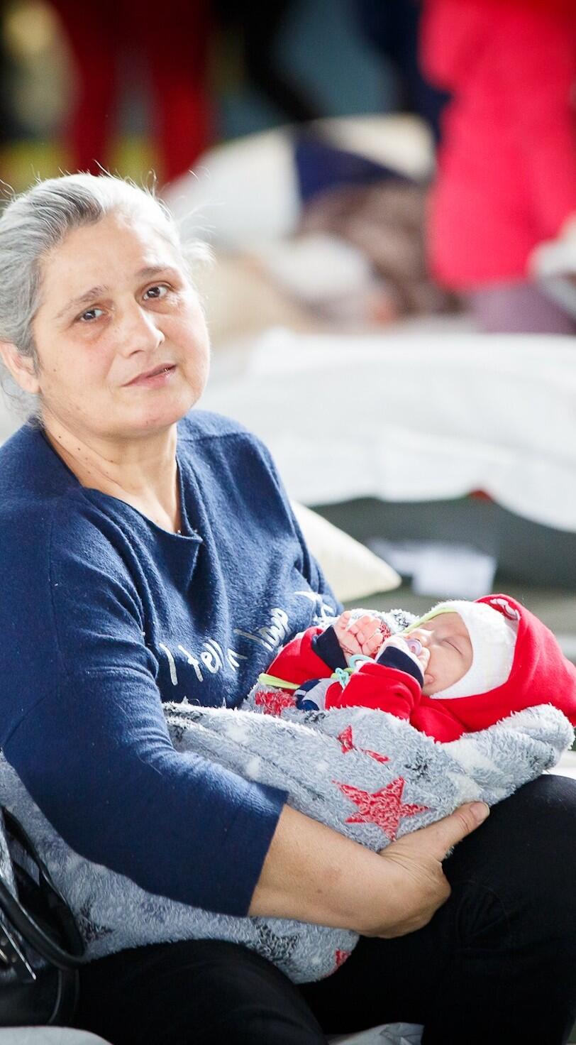 A grandmother holds her infant grandchild. 