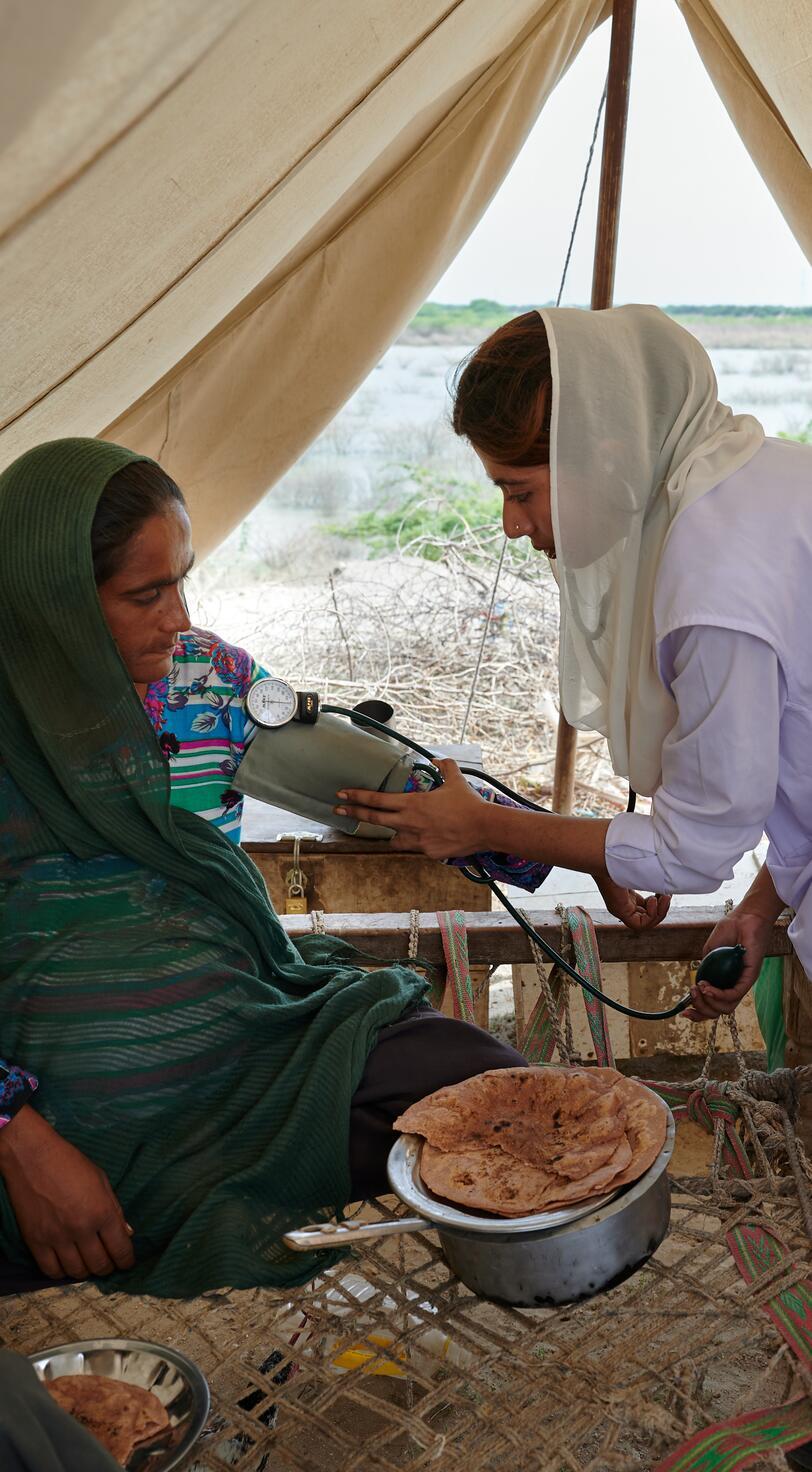 Healthcare workers assist a woman.