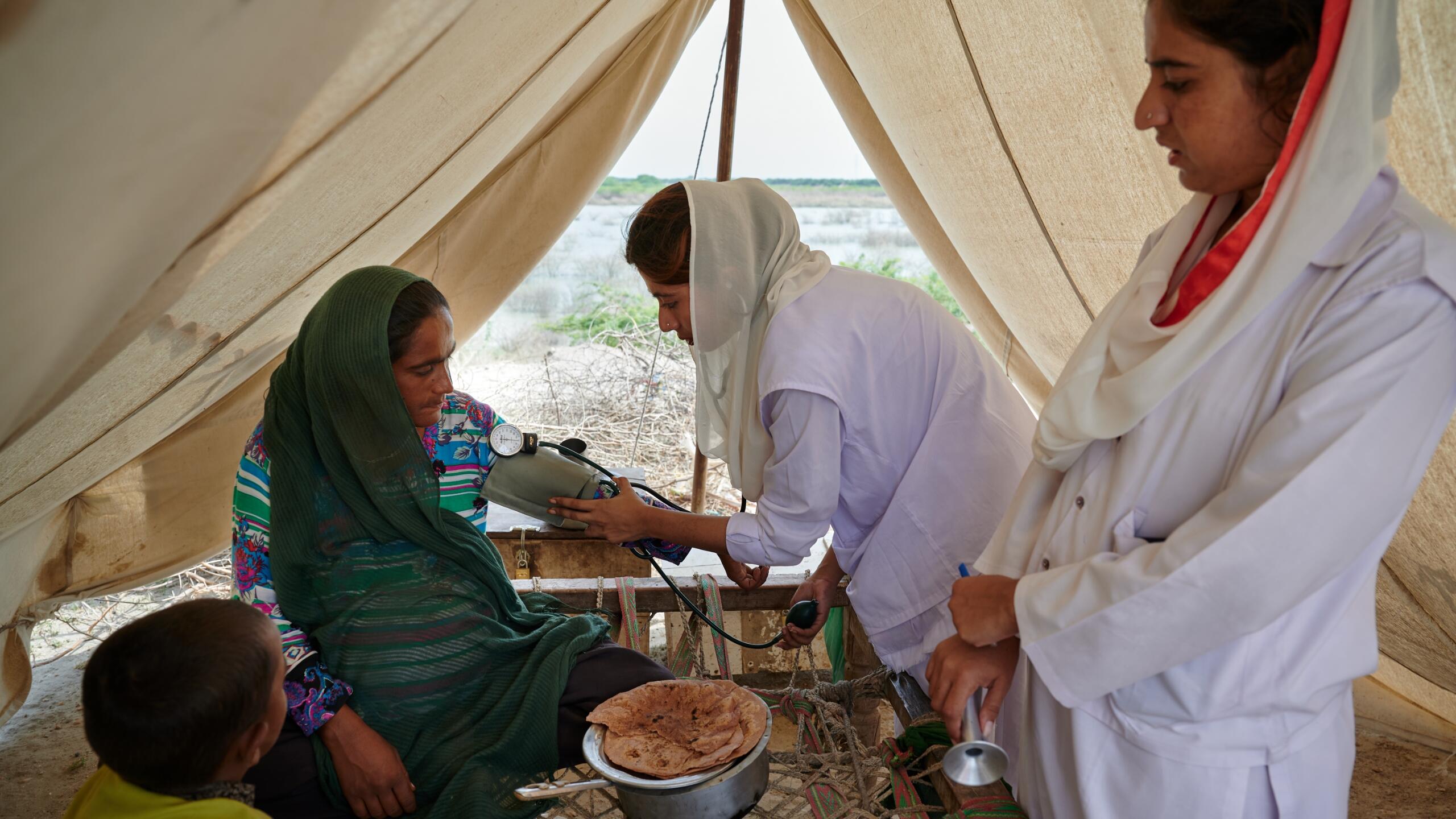 Healthcare workers assist a woman.