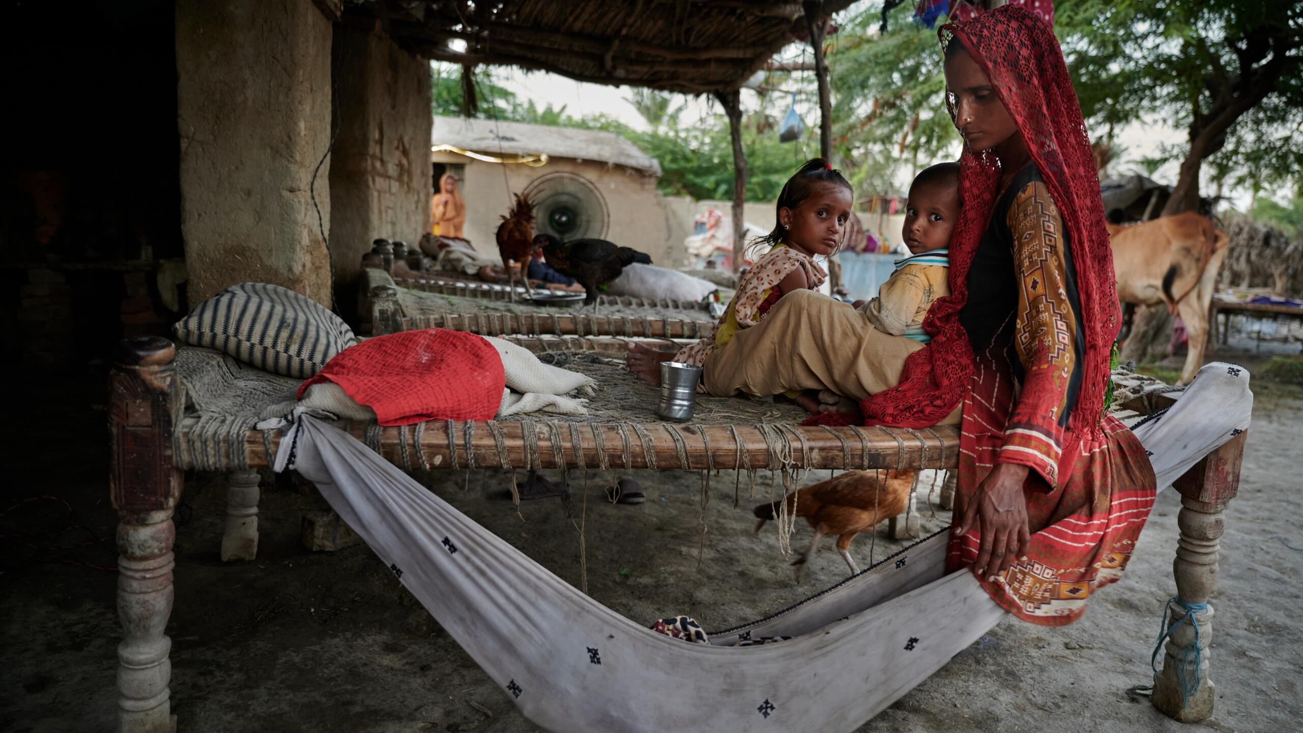 A mother tends to a baby in a hammock.