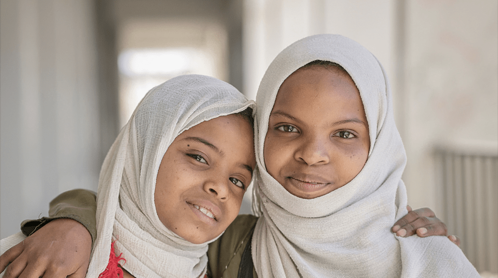 Two young girls smiling. 