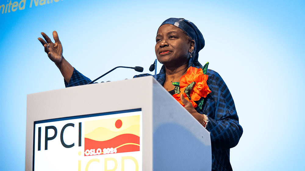 UNFPA Executive Director Dr.Natalia Kanem stands behind a lectern and gestures while speaking.