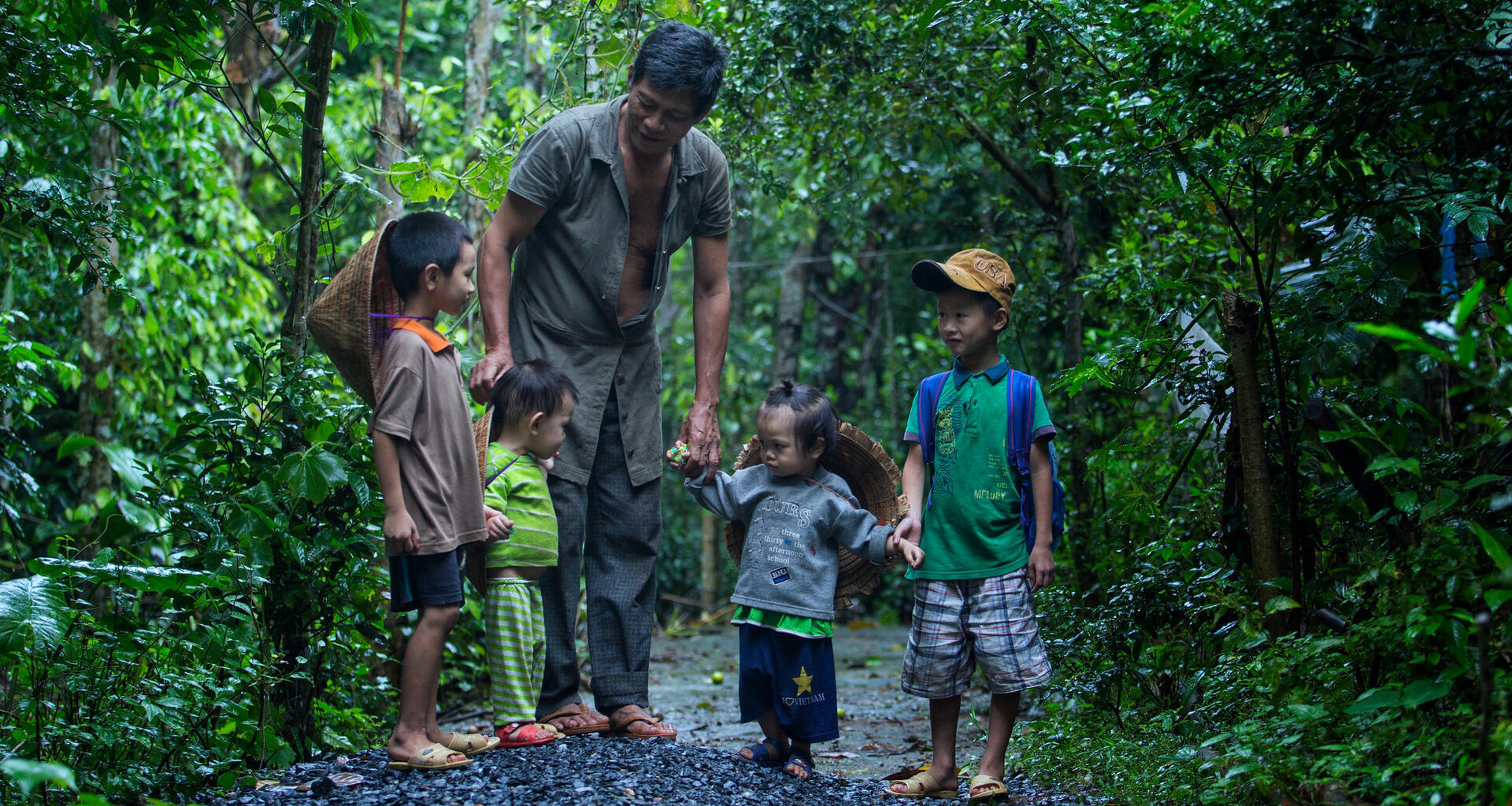 Un hombre está de pie con niños pequeños.