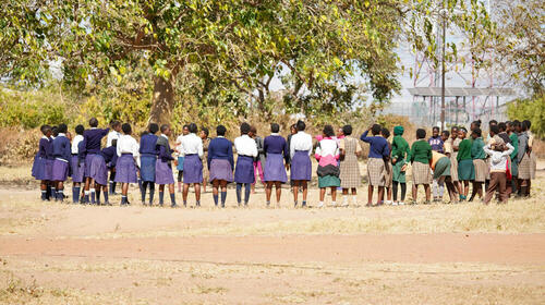 Des filles sont regroupées devant une école