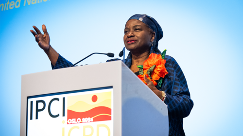 UNFPA Executive Director Dr.Natalia Kanem stands behind a lectern and gestures while speaking.